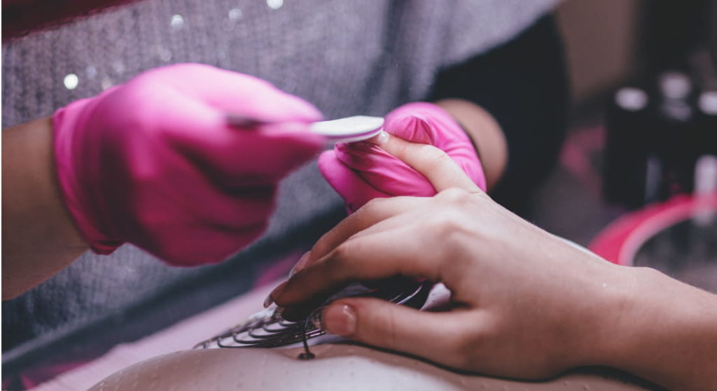 Fiche métier prothésiste ongulaire - Prothésiste ongulaire réalise un soin - lime les ongles pour pose de vernis et manucure